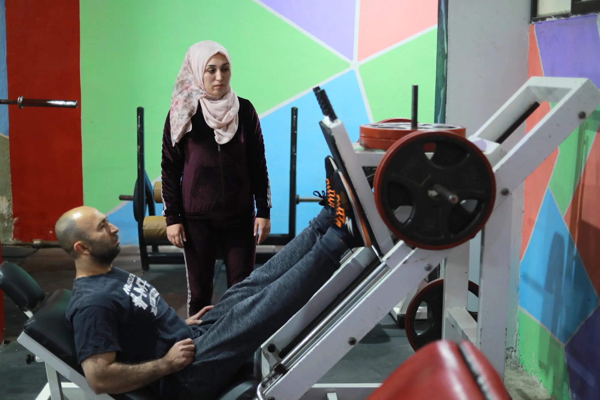 A man and a woman exercise in a gym